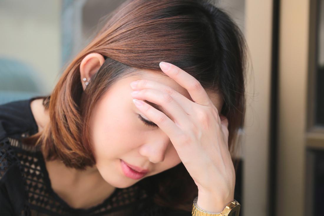 lady holding head in hands