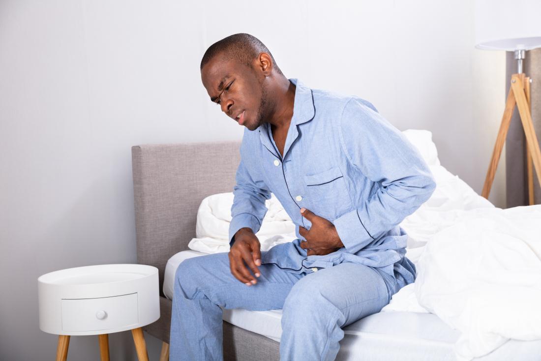 man holding stomach in pain due to duodenal cancer
