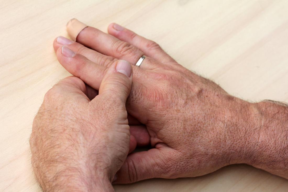 person with finger pain holding hands due to injury