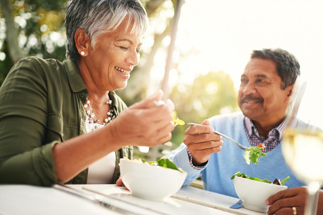 older couple eating a salad outdoors