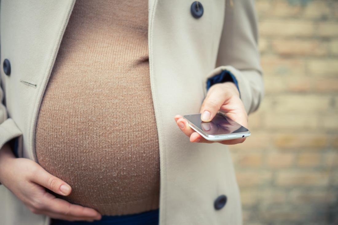 pregnant lady holding smart phone
