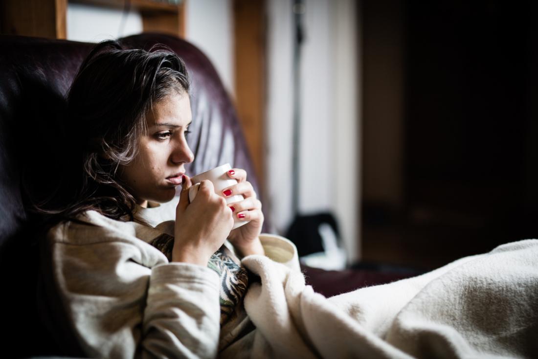 young woman in bed with tea