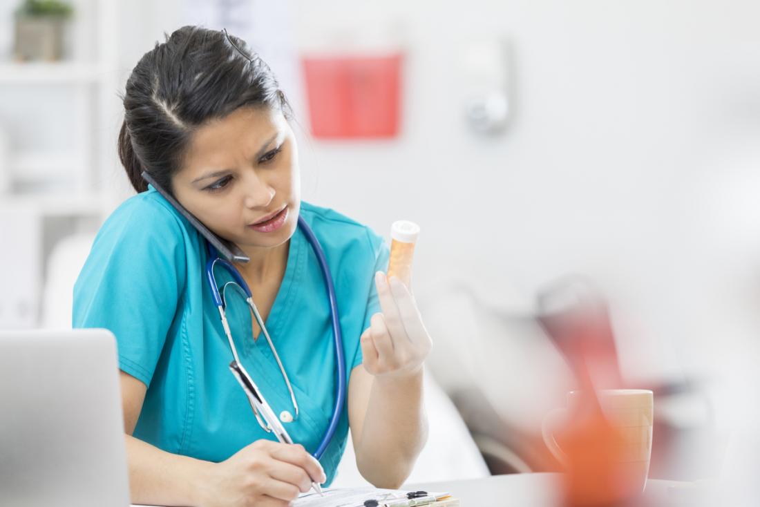 medical professional reading a prescription bottle