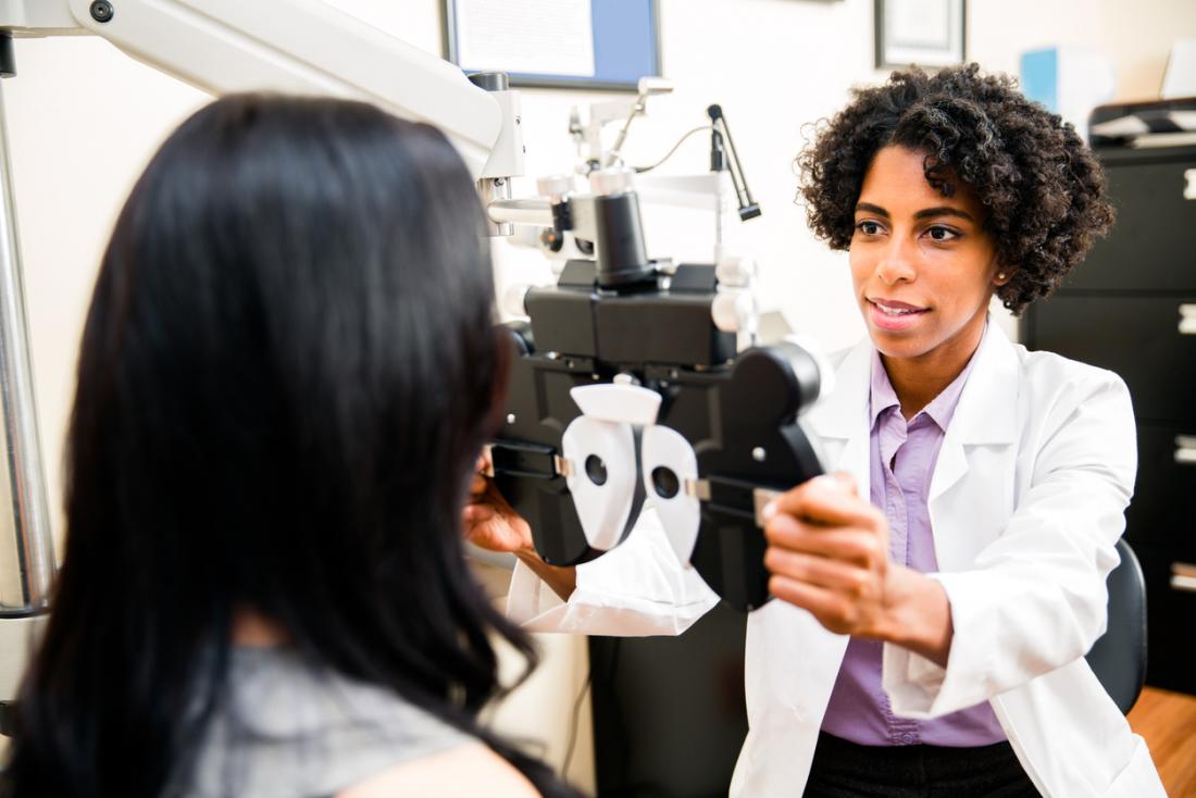 Female optician carries out an eye test on a female patient