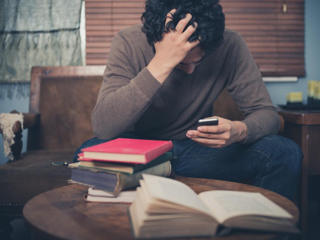 man sitting depressed with his phone