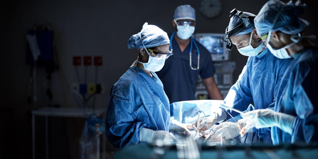 Surgery being performed by group of surgeons.