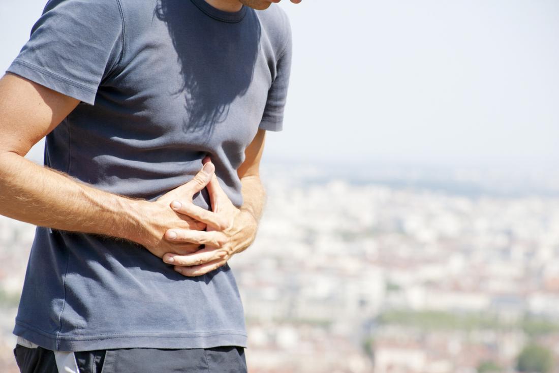 Man holding stomach in pain.