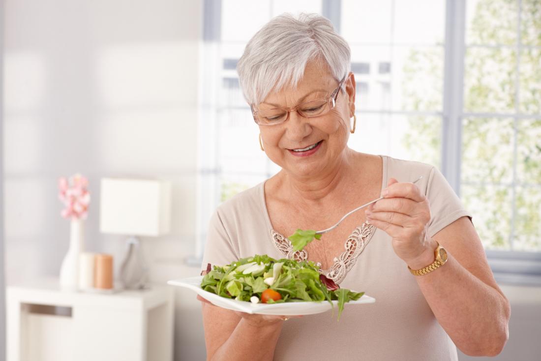 an older woman eating a salad