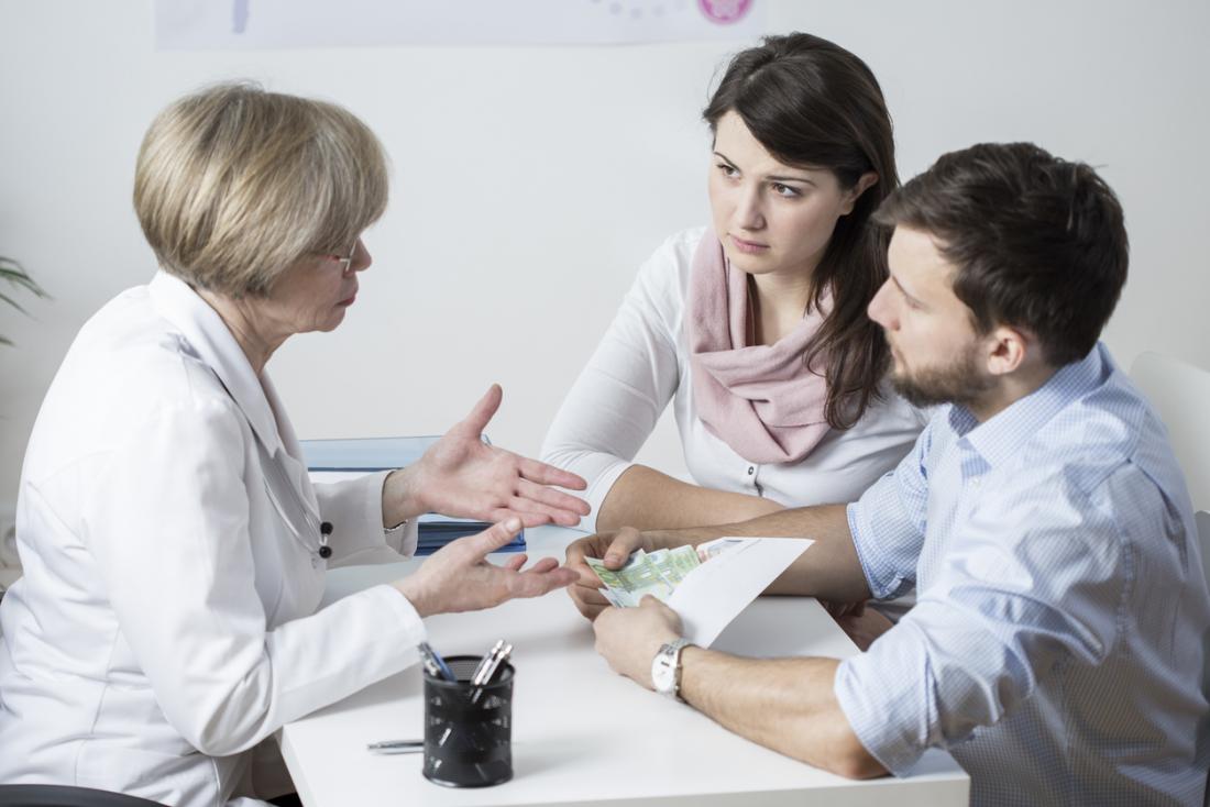Couple discussing fertility treatment with doctor.