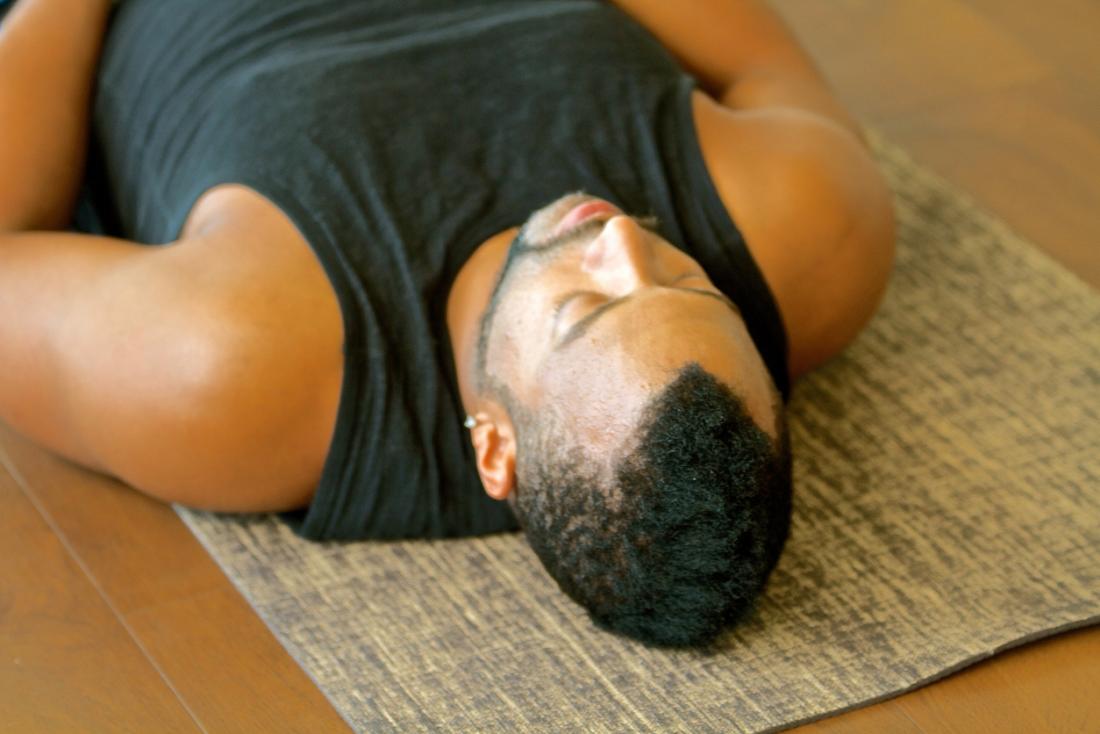Man practicing yoga and relaxation techniques.