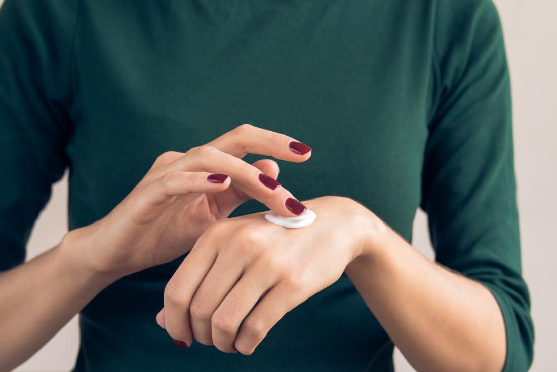 Applying cream to the back of the hand.
