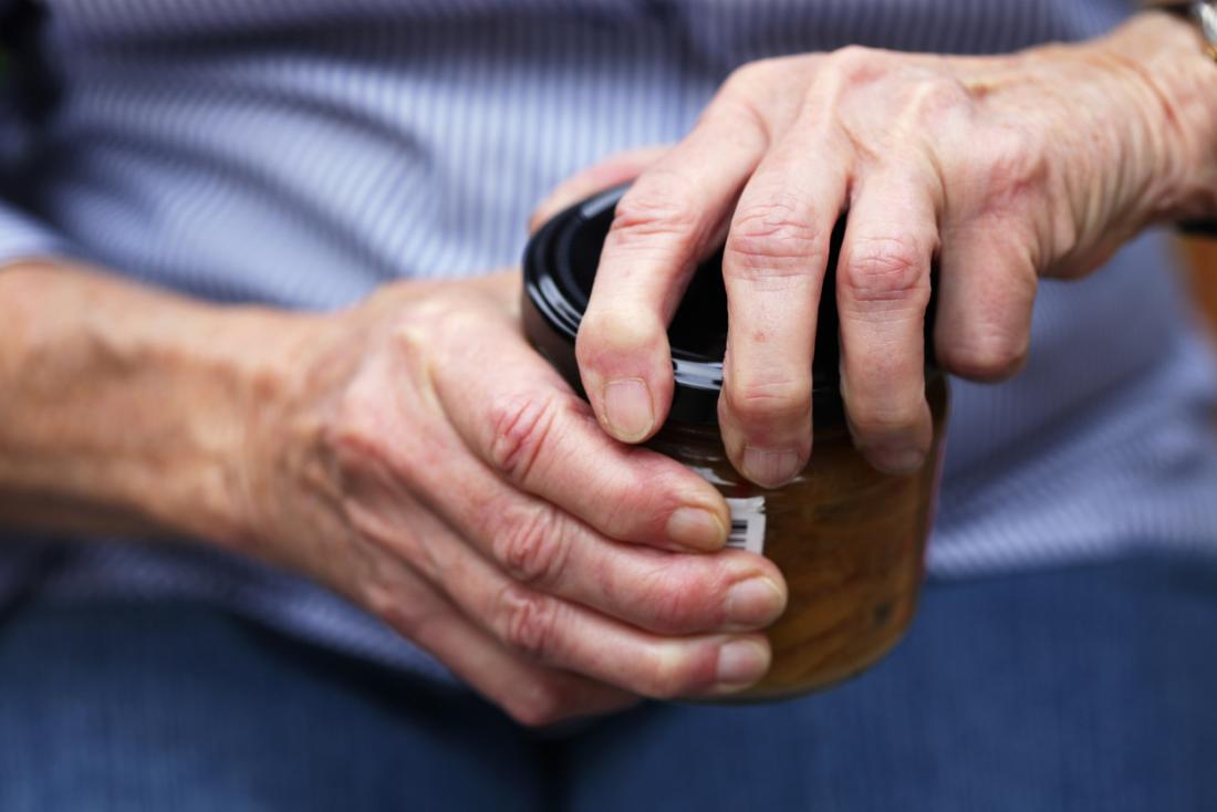 Elderly person with arthritis opening a jar.