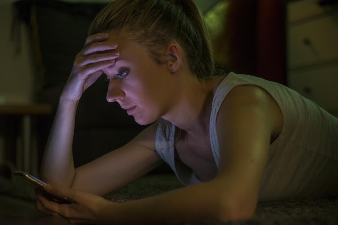 Woman looking sad holding her phone