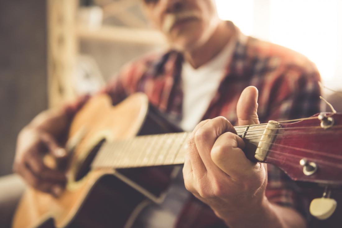 senior man playing a guitar