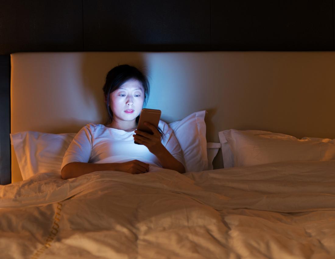 lady using smart phone in bed