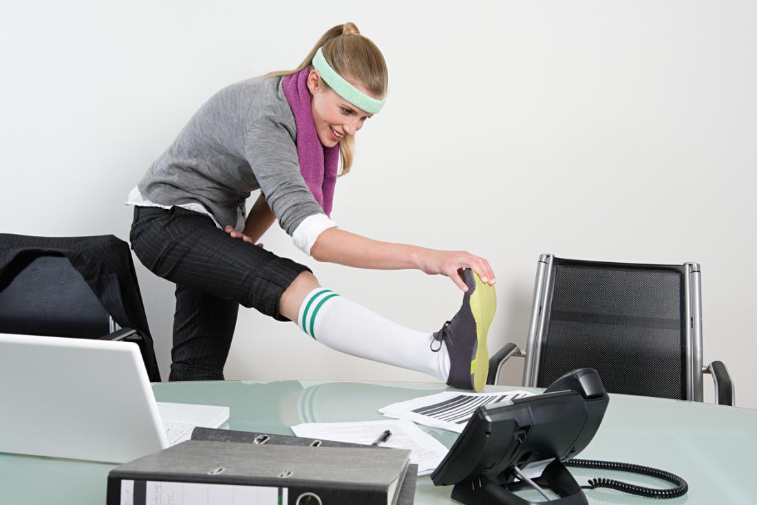a woman stretching at her desk
