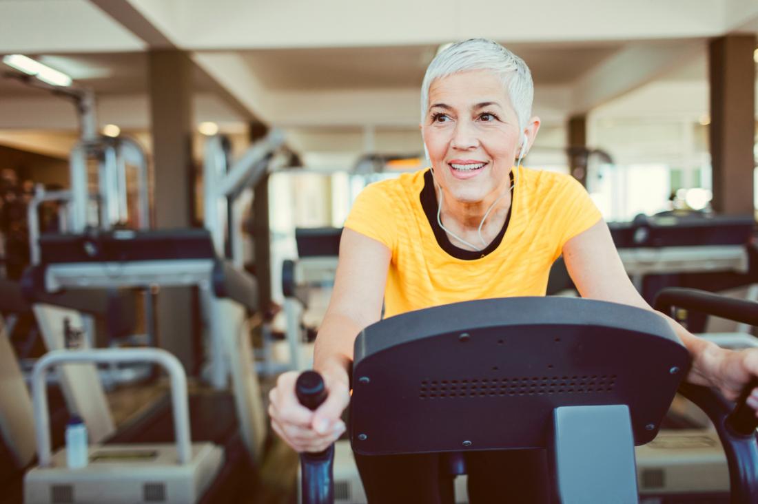 Mature woman on exercise bike in gym.