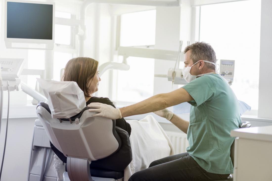 Male dentist preparing a female patient.