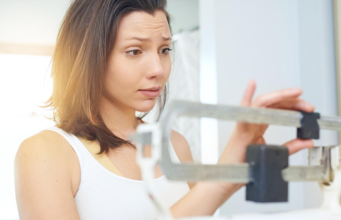 woman adjusting scales