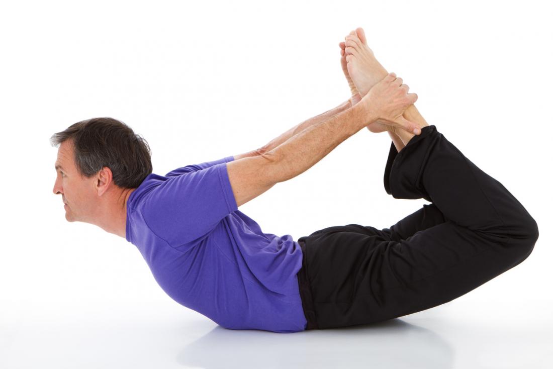 man doing yoga in the bow pose or dhanurasana