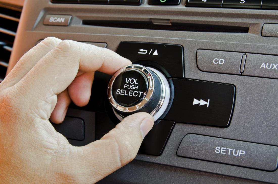 Radio volume dial in car being turned.