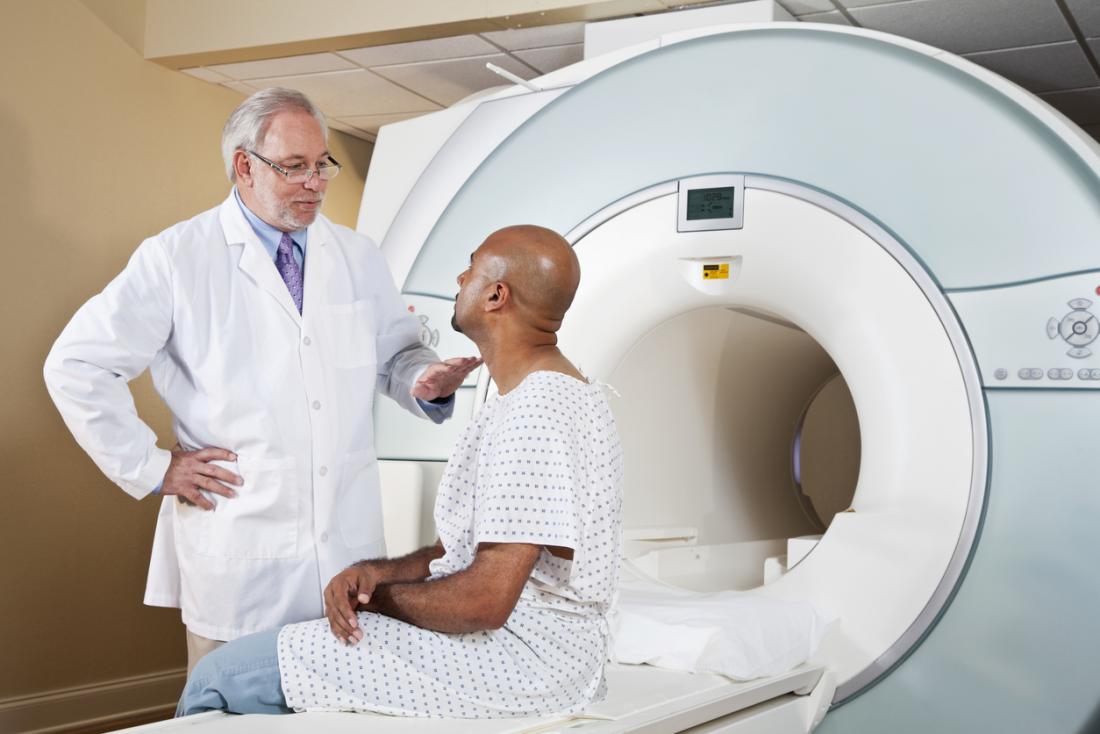 Doctor talking to a patient on MRI machine about to have an MRI scan.