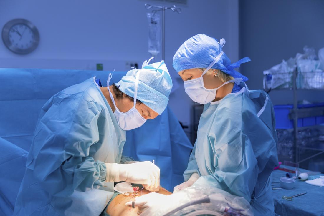 Surgeons in operating theater performing surgery on a patient.