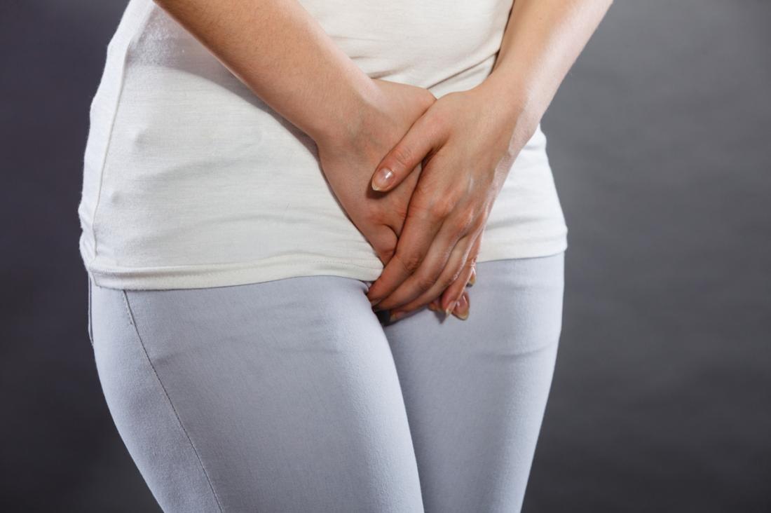 woman covering her crotch with her hands on white background Stock Photo