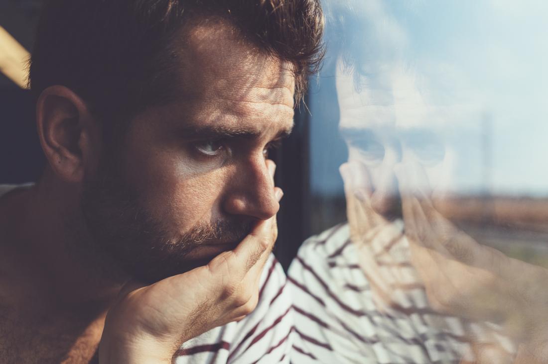 sad man looking out of a window