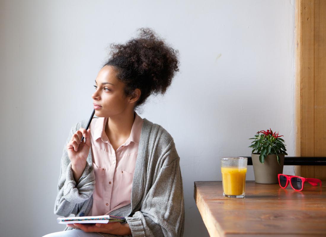 woman thinking while holding a notebook
