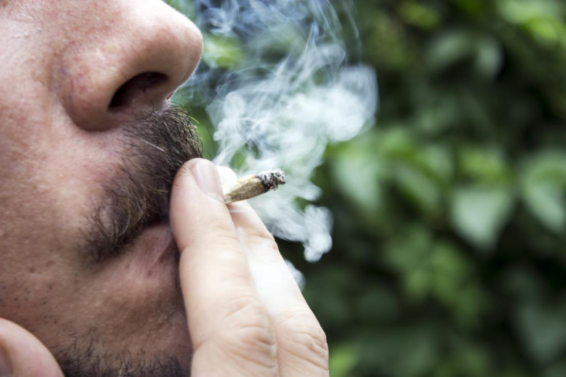 Man smoking a marijuana joint.