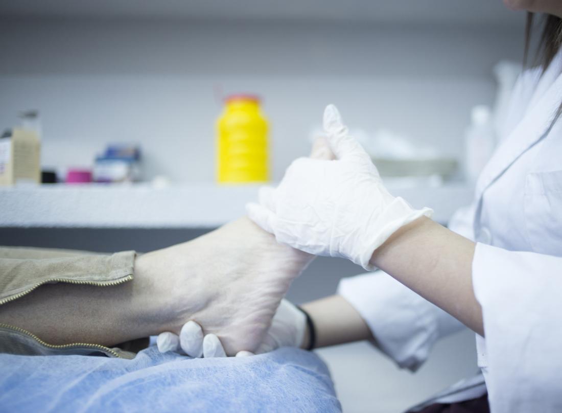 Podiatrist inspecting patients foot.