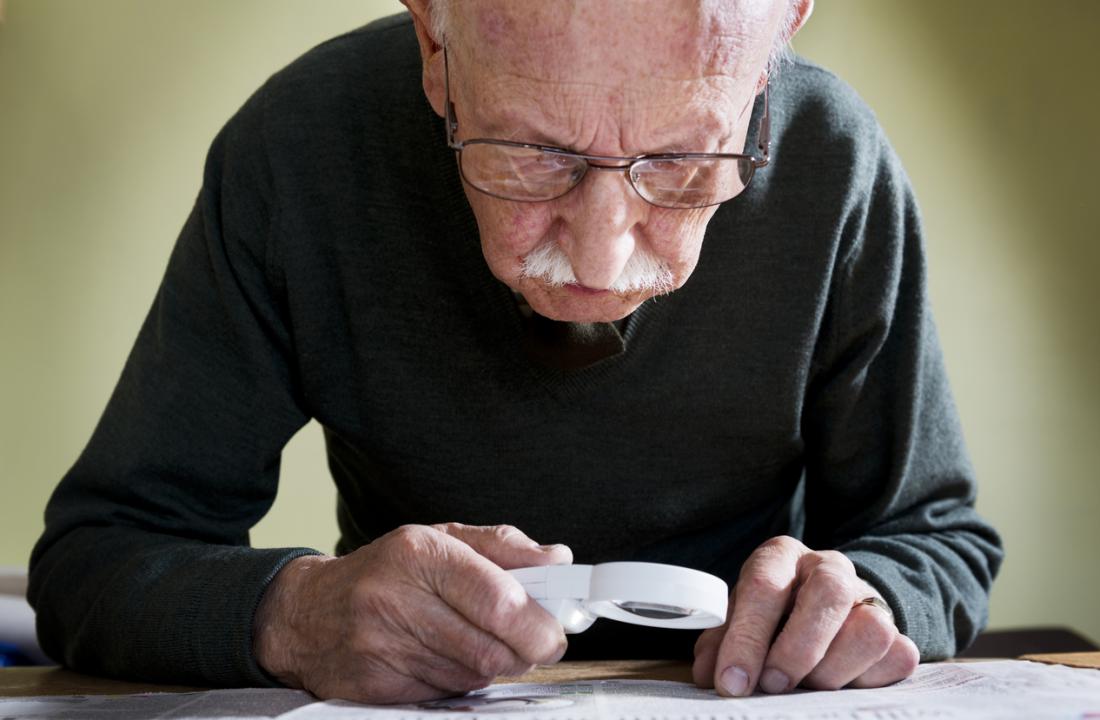 senior reading with magnifying glass
