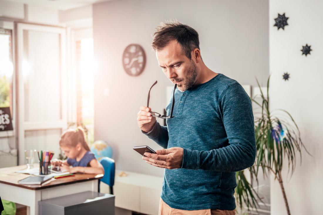 father looking worried while reading his phone