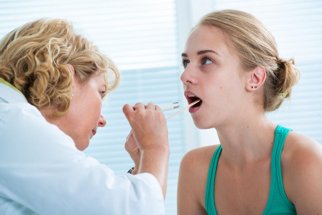 Doctor examining tongue and throat.
