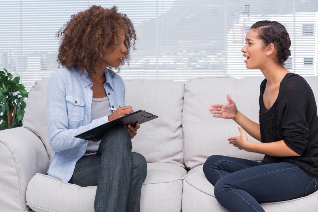 Lady sits on a couch speaking to her therapist