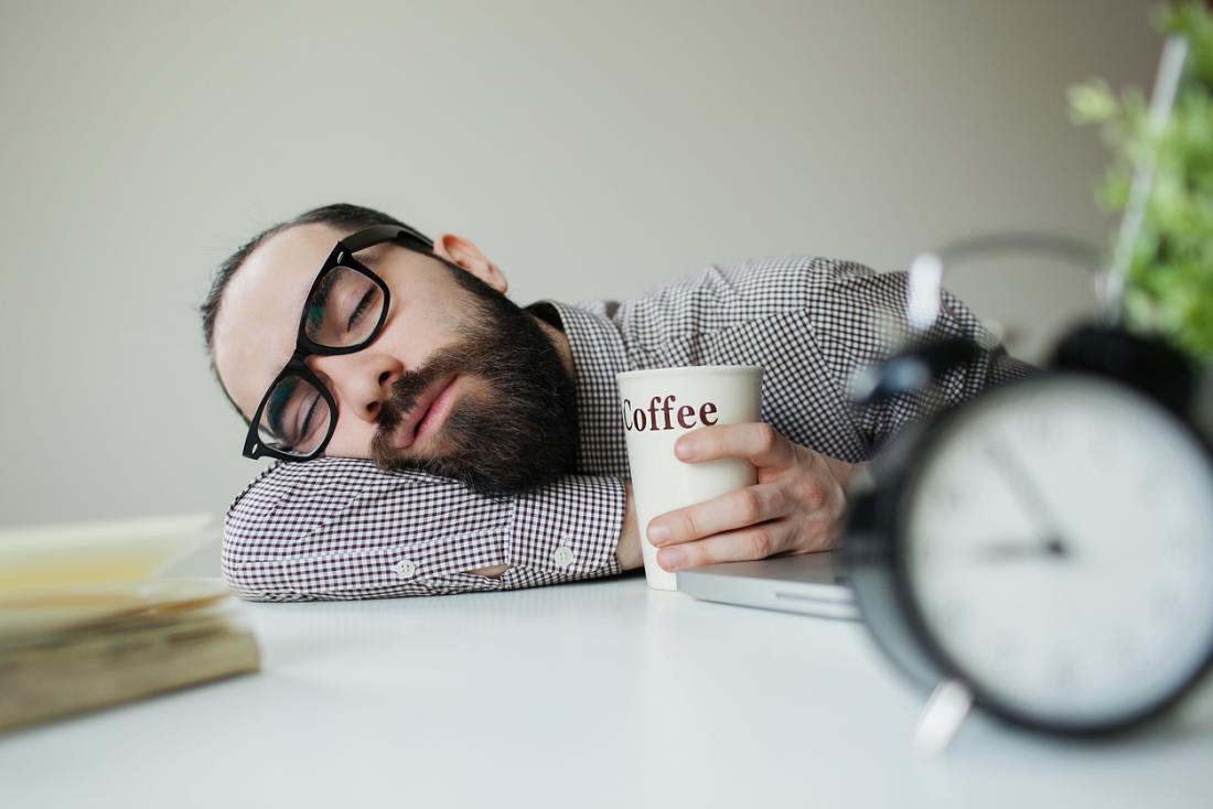 man with glasses asleep on a desk