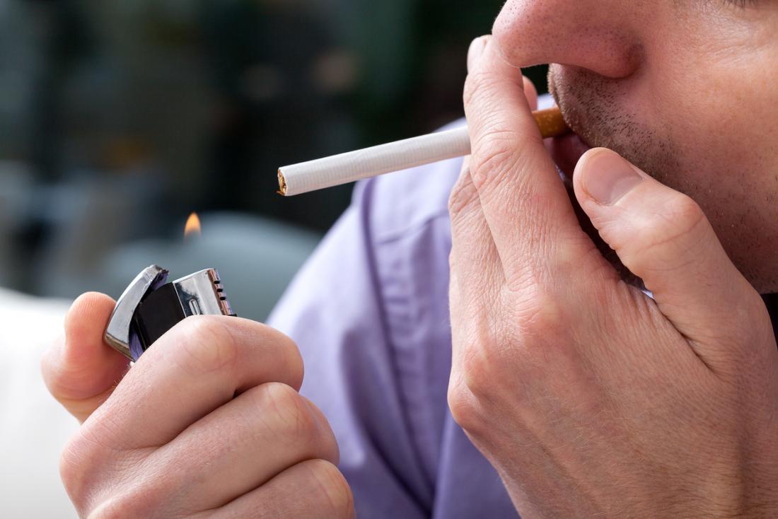 man lighting up a cigarette