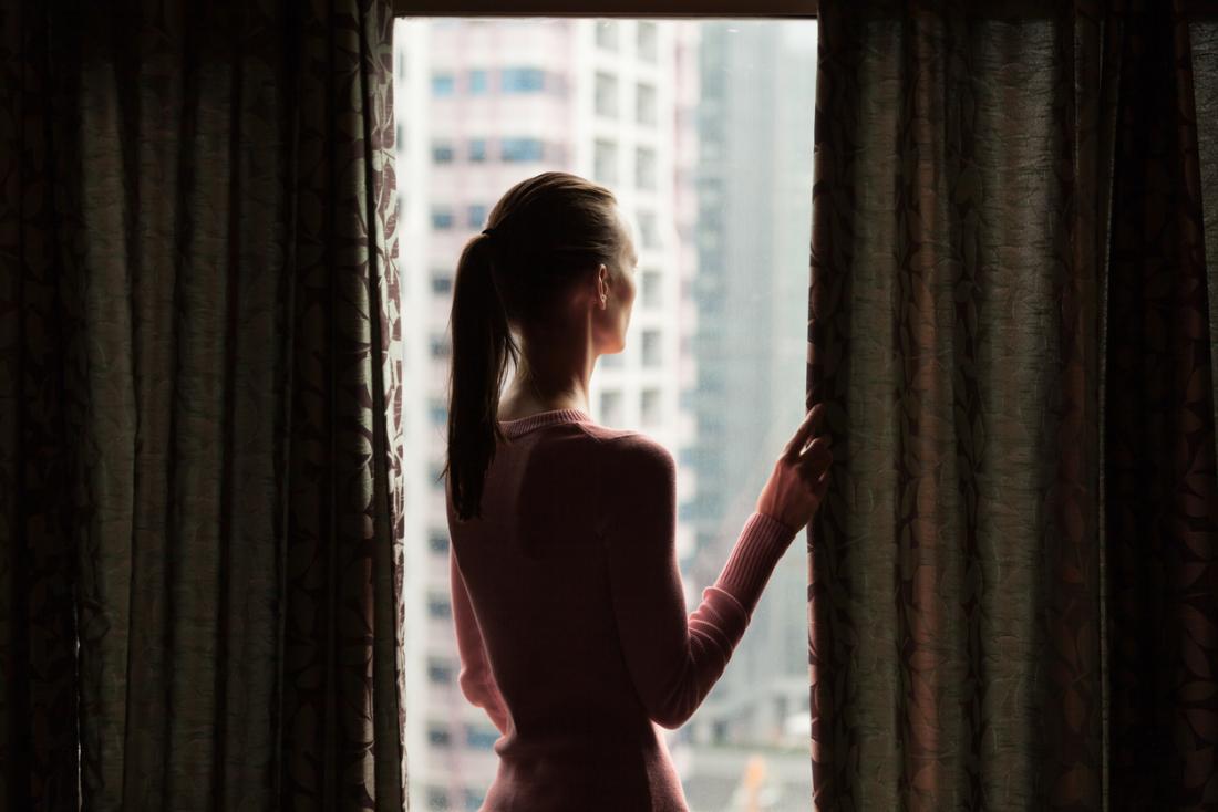 Sad woman looking out of window.