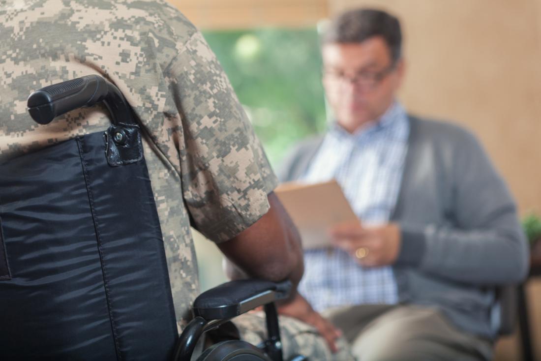 Veteran in wheelchair having therapy with counselor.