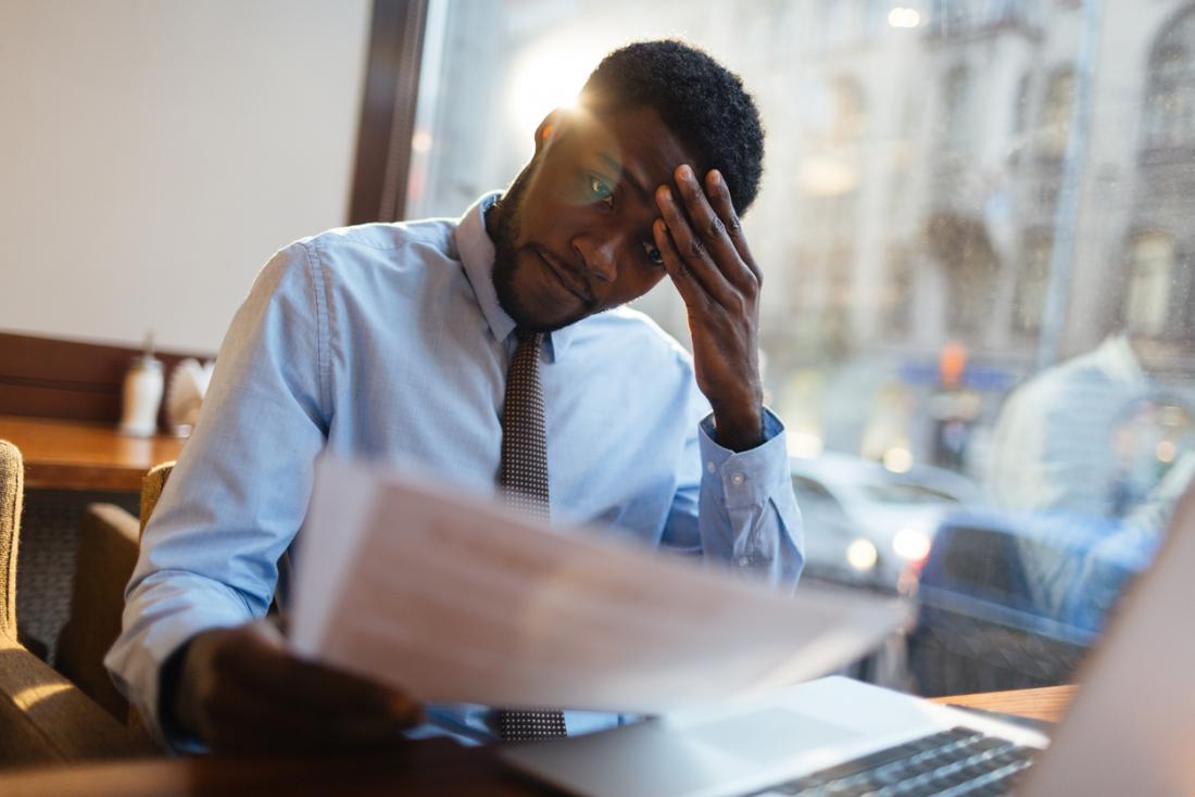 Business man working hard, stressed with headache.