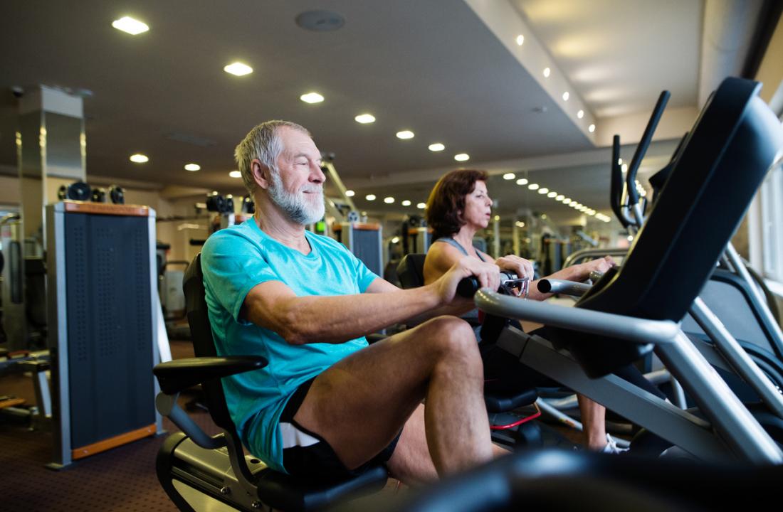 senior man on recumbent exercise bike in gym.