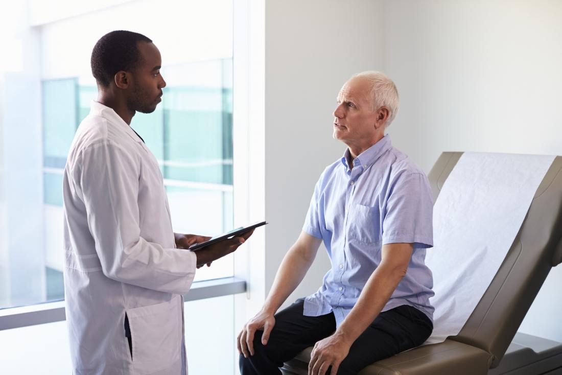 Senior male patient speaking to young male doctor.