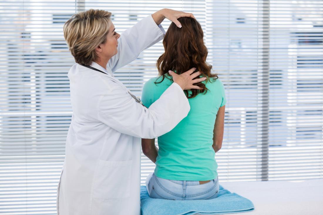 doctor examining women's head and neck