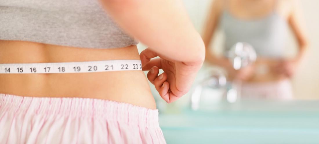 woman measuring her waist