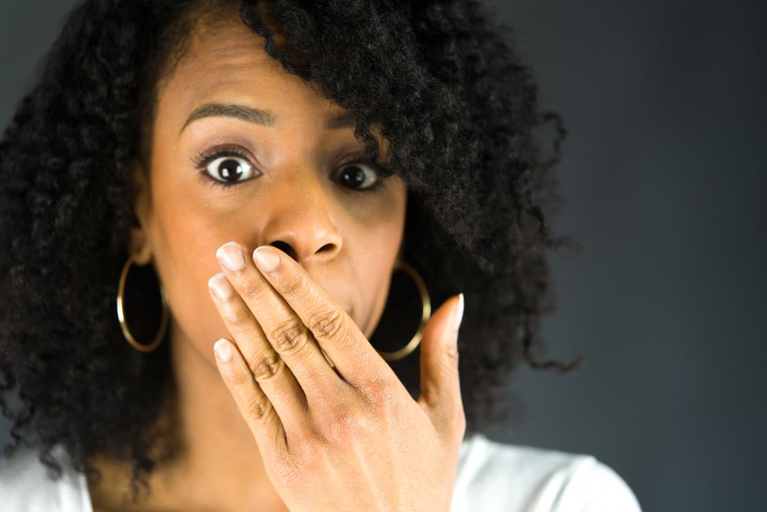 woman covering her mouth with one hand