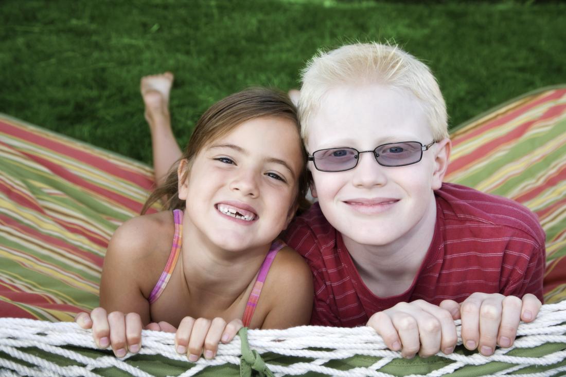 Young boy with albinism, next to young girl without.
