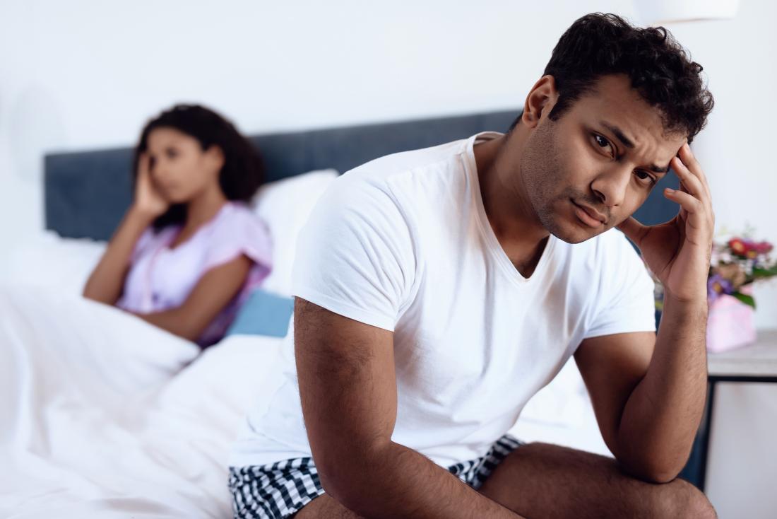 Man and woman in bed looking upset, having sexual intimacy problems.