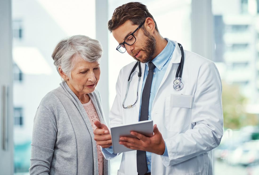 Young male doctor speaking with mature female patient.