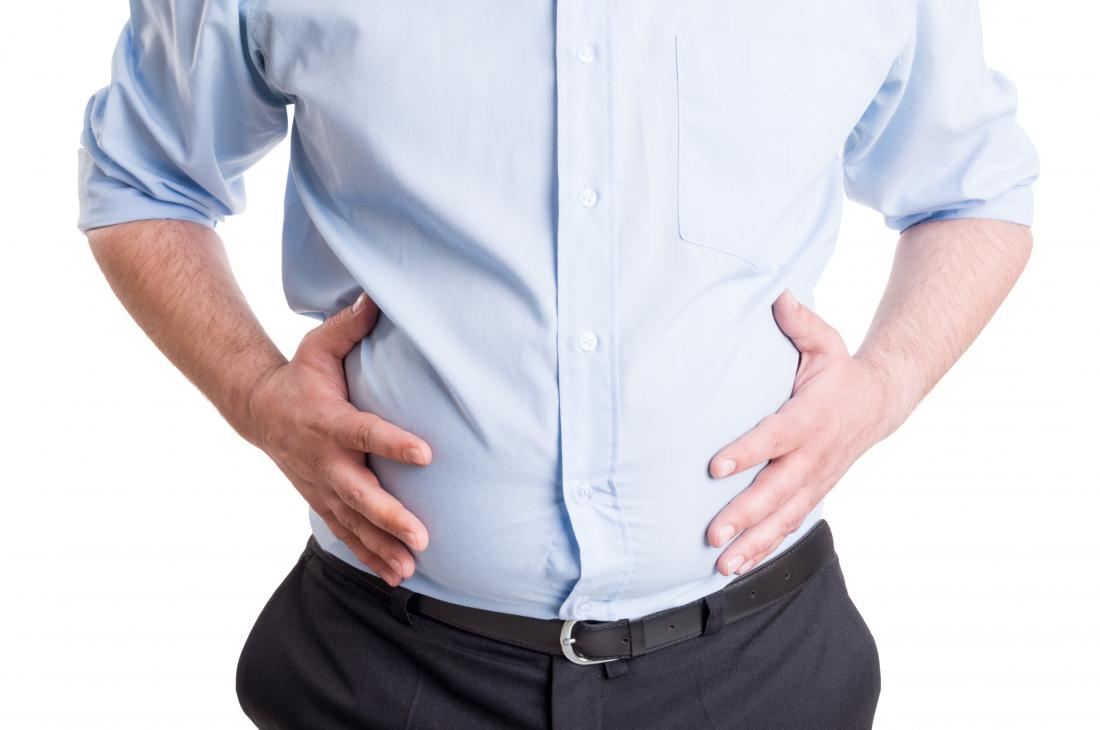 man holding round stomach